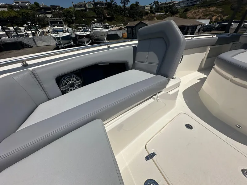 Slide: The Image of 2025 Boston Whaler 360 Outrage boat interior with gray seating and storage compartments. - 19