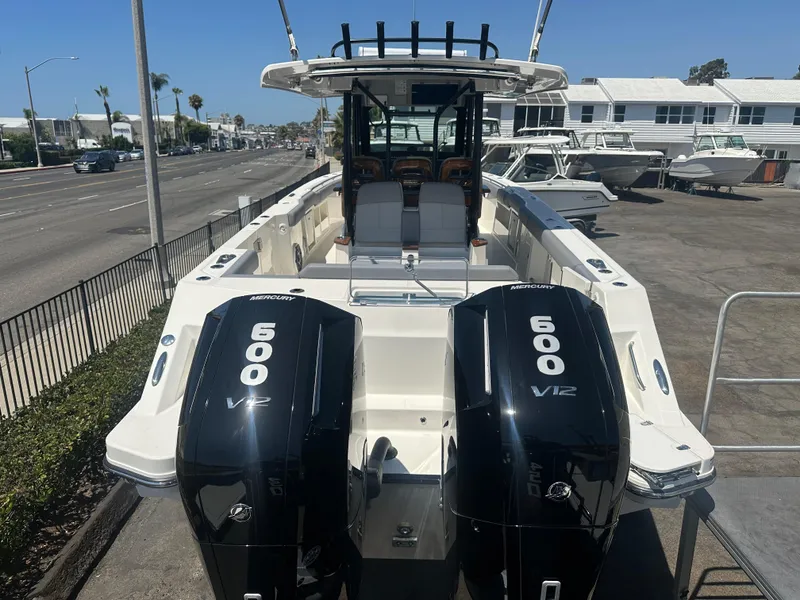 Slide: The Image of 2025 Boston Whaler 360 Outrage boat with dual 600 V12 engines, docked outdoors. - 3
