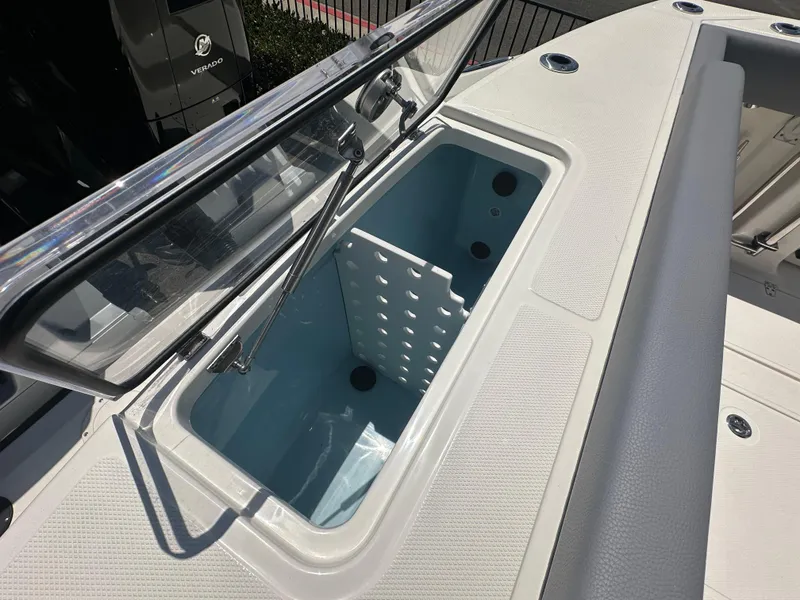 Slide: The Image of 2025 Boston Whaler 360 Outrage boat storage compartment with open lid, showcasing interior design. - 7