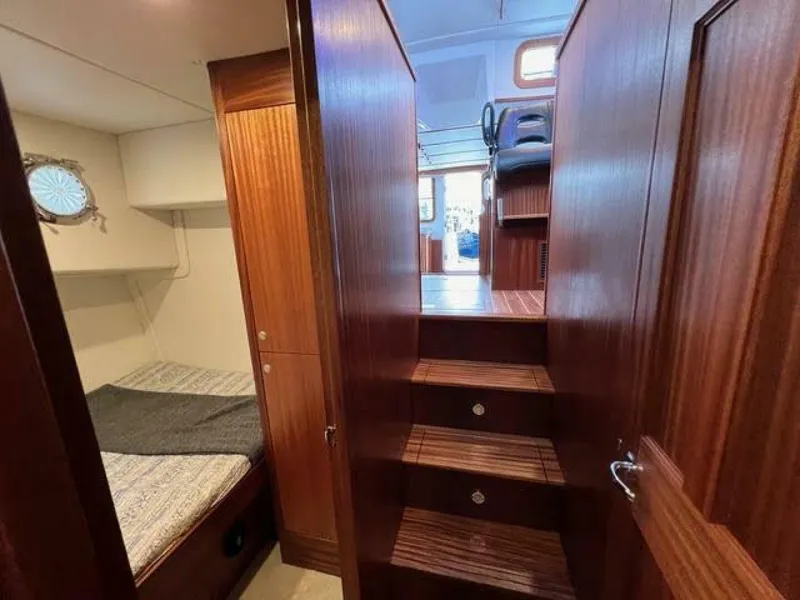 Slide: The Image of Interior of 2024 Nordic Tug 40, featuring wooden stairs and cozy cabin space. - 24