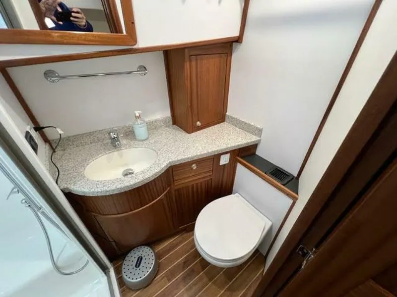 Slide: The Image of 2024 Nordic Tug 40 bathroom with wood cabinetry, granite countertop, and modern fixtures. - 28