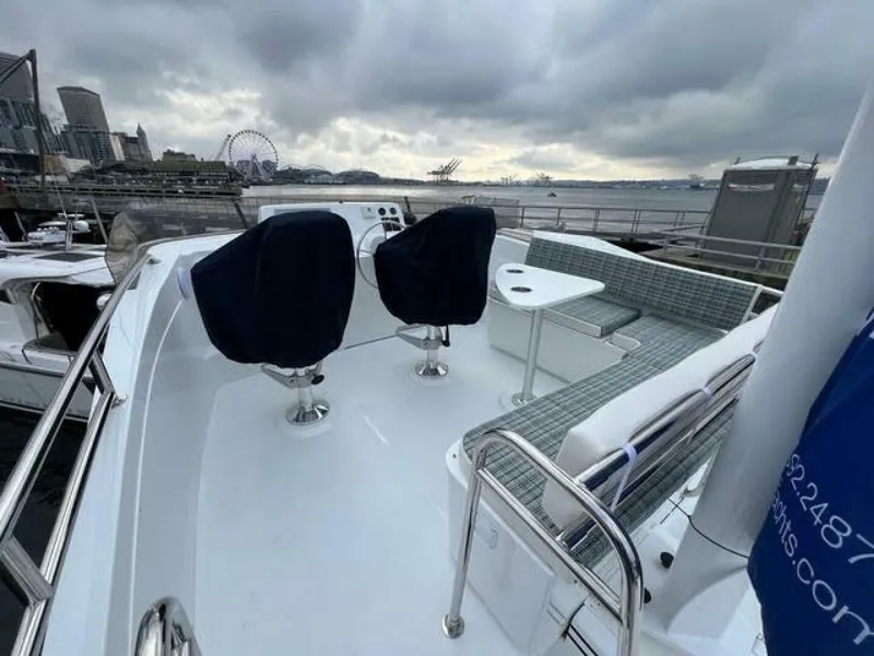 Slide: The Image of 2024 Nordic Tug 40 boat deck with seating, overlooking a waterfront cityscape. - 29