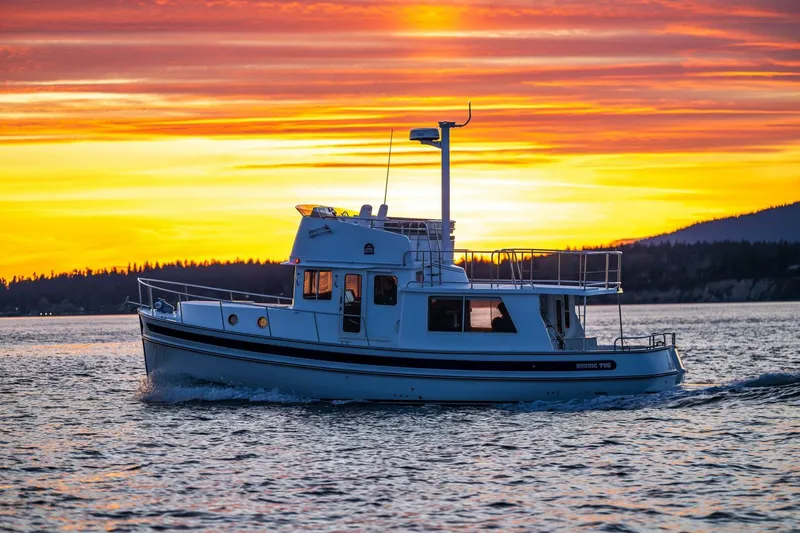 Slide: The Image of 2024 Nordic Tug 40 cruising at sunset on serene waters. - 39