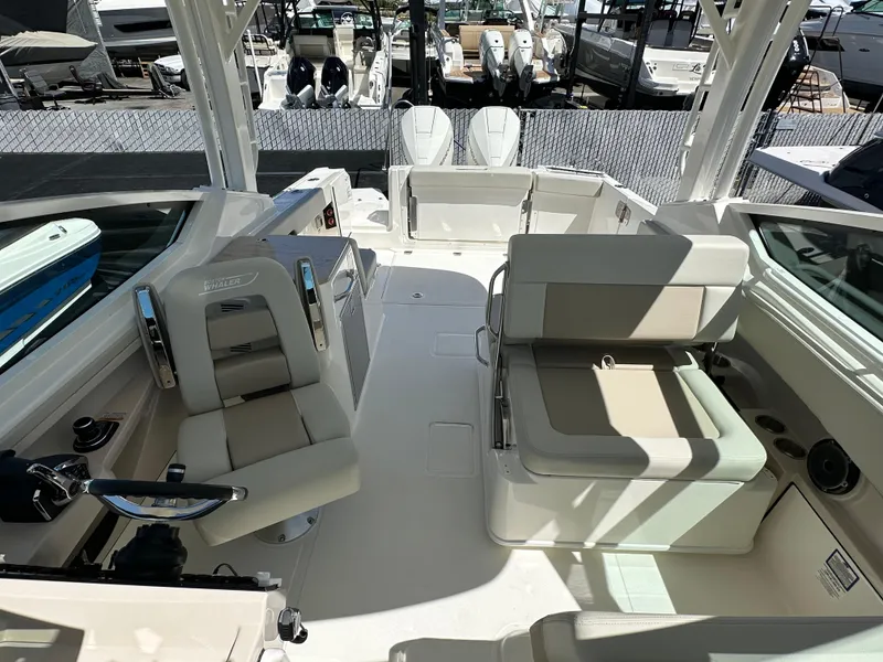 Slide: The Image of 2024 Boston Whaler 280 Vantage boat interior with seating and helm station. - 23