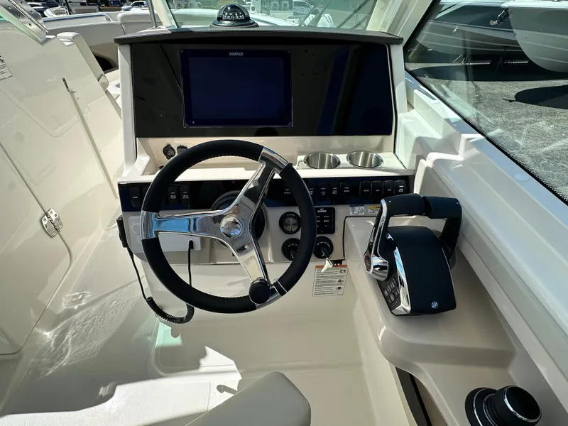 Slide: The Image of 2024 Boston Whaler 280 Vantage boat helm with steering wheel and control panel. - 24