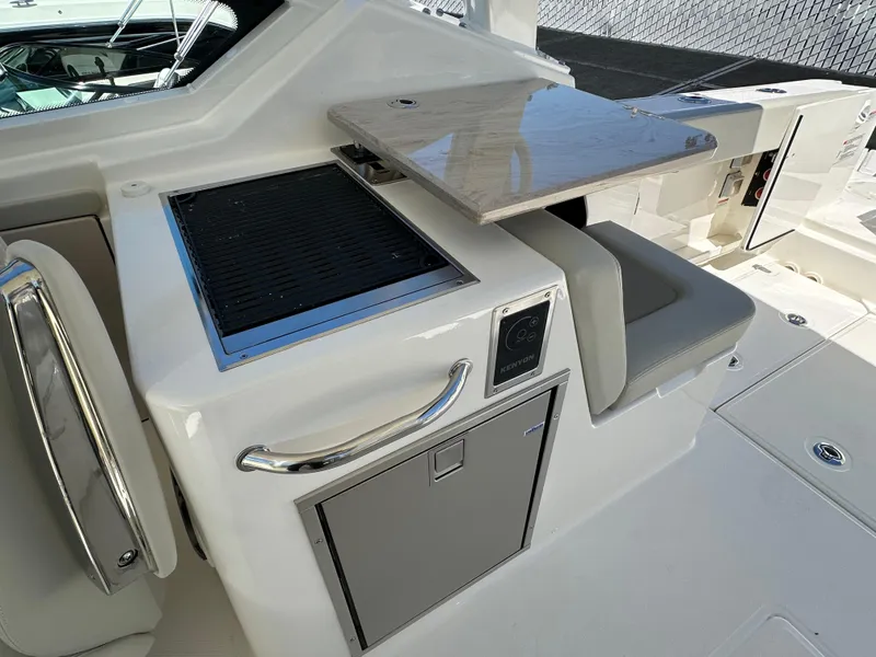 Slide: The Image of 2024 Boston Whaler 280 Vantage boat interior with seating and built-in grill. - 8