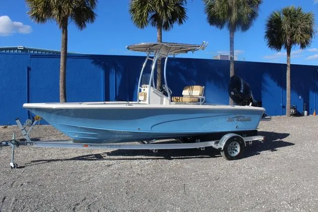 Slide: The Image of 2023 Sea Chaser 21 LX boat on trailer with palm trees in the background. - 3