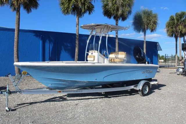 Slide: The Image of 2023 Sea Chaser 21 LX boat on trailer, blue hull, palm trees in background. - 4