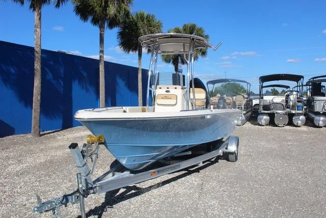 Slide: The Image of 2023 Sea Chaser 21 LX boat on trailer in a marina with palm trees. - 6