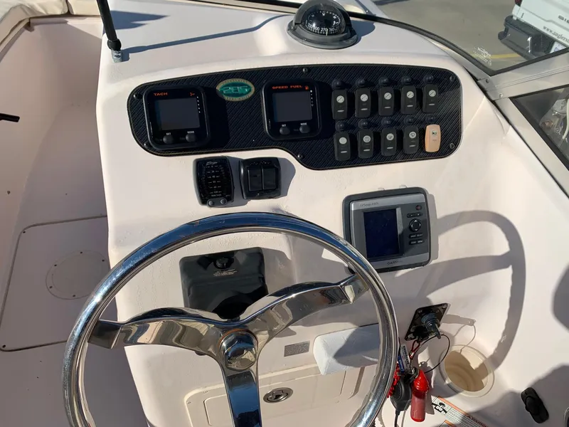 Slide: The Image of 2009 Grady-White Tournament 205 boat dashboard with steering wheel and control panel. - 18