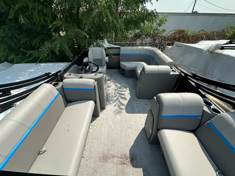 Slide: The Image of 2023 Qwest 818 Lanai LT pontoon boat interior with gray seating and blue accents. - 2