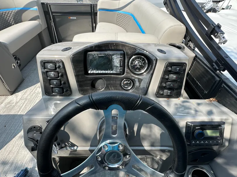 Slide: The Image of 2023 Qwest 818 Lanai LT boat dashboard with steering wheel and control panel. - 8