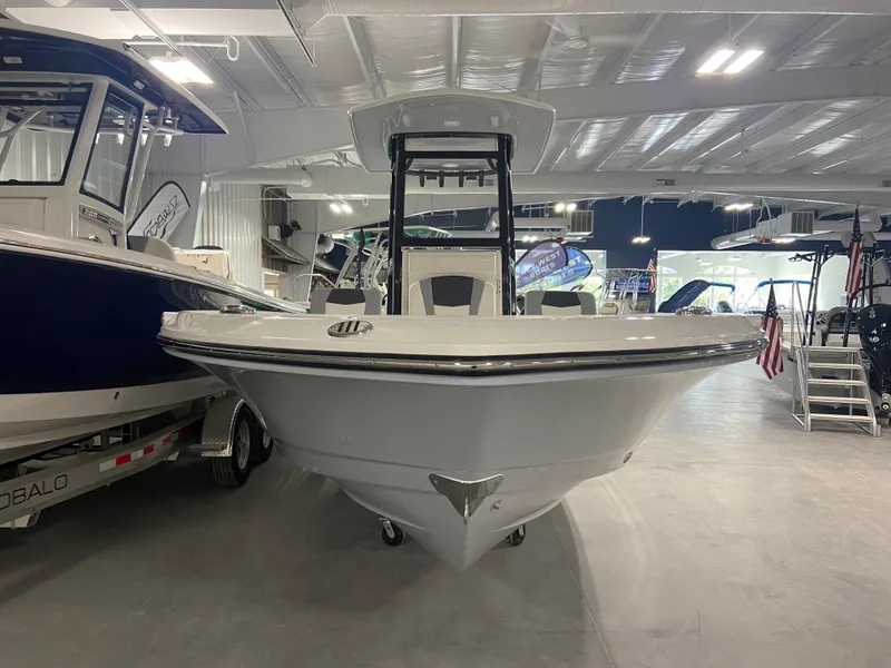 Slide: The Image of 2024 Robalo 246 Cayman boat displayed in a showroom. - 1