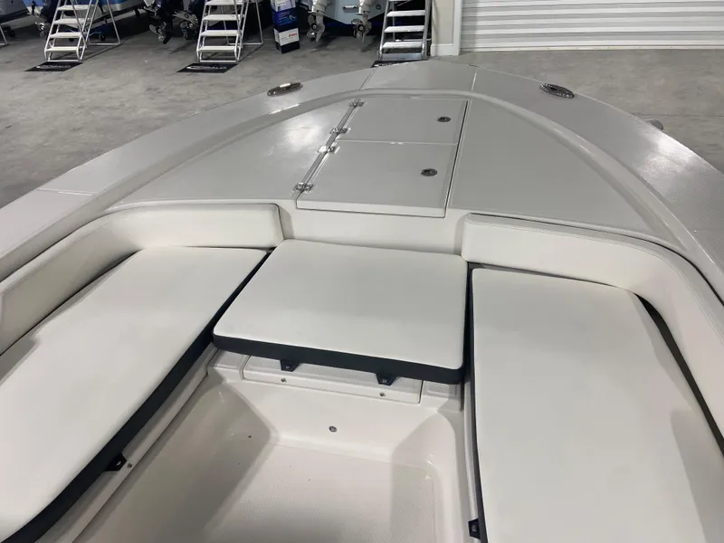 Slide: The Image of 2024 Robalo 246 Cayman boat interior with cushioned seating and storage compartments. - 10