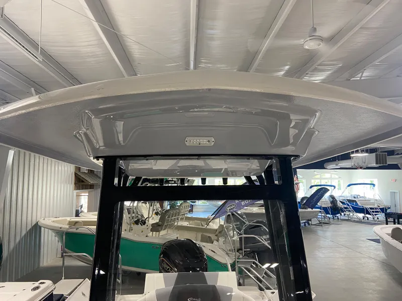 Slide: The Image of 2024 Robalo 246 Cayman boat displayed in an indoor showroom. - 13