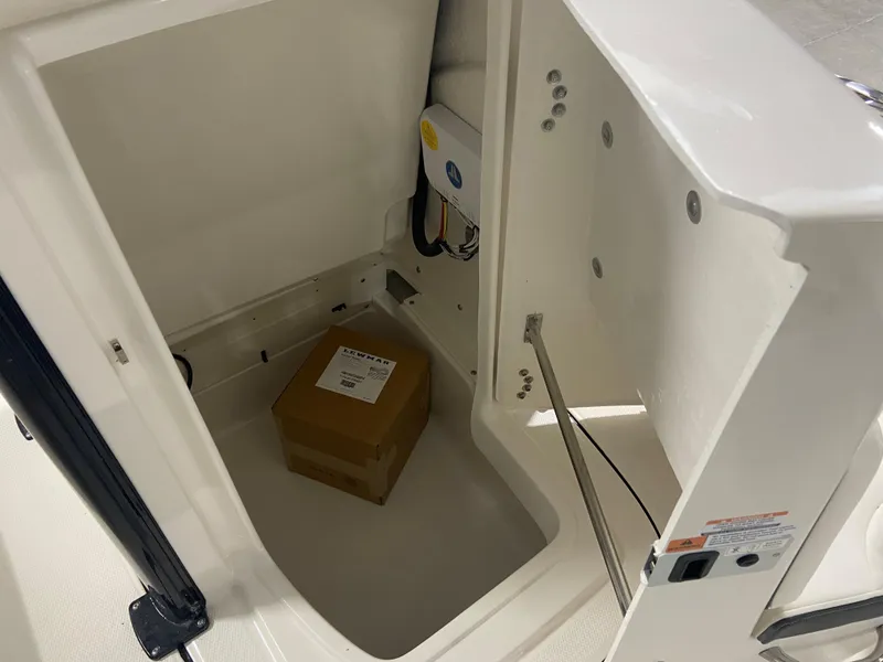 Slide: The Image of 2024 Robalo 246 Cayman storage compartment with a cardboard box inside. - 19
