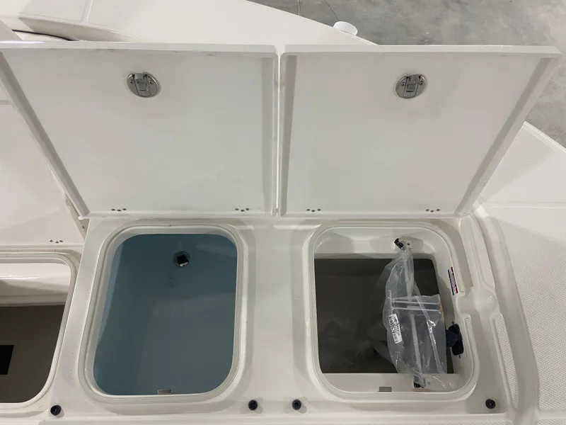 Slide: The Image of 2024 Robalo 246 Cayman boat storage compartments open, showcasing interior space. - 20