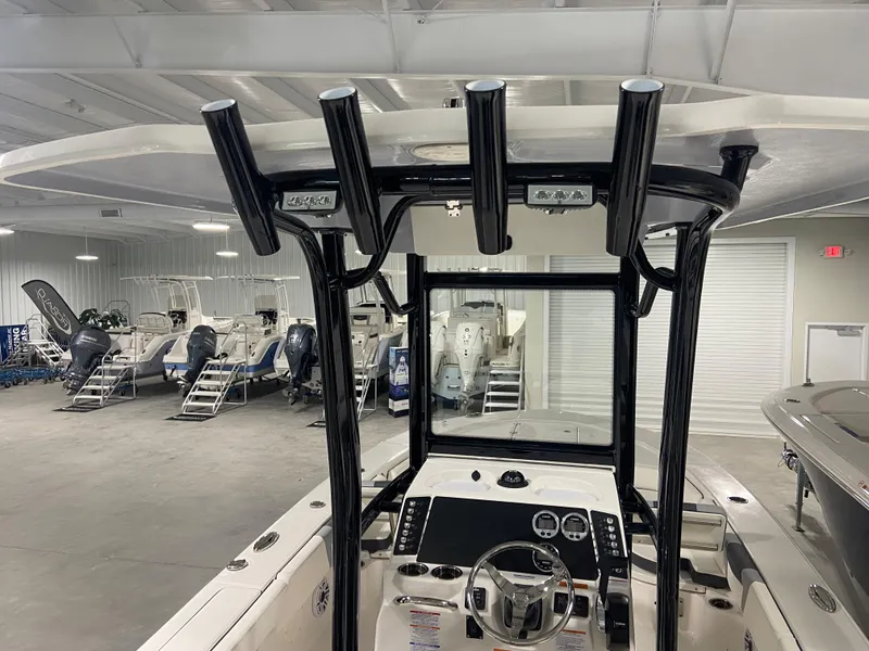 Slide: The Image of 2024 Robalo 246 Cayman boat interior with T-top and control console in showroom. - 6