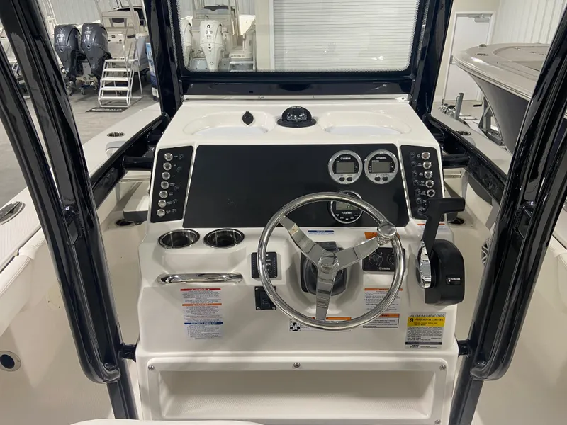 Slide: The Image of 2024 Robalo 246 Cayman boat console with steering wheel and controls. - 9