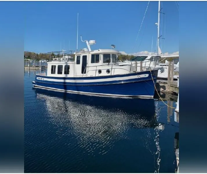 Slide: The Image of 2010 Nordic Tug 32 boat docked in a marina on a sunny day. - 10