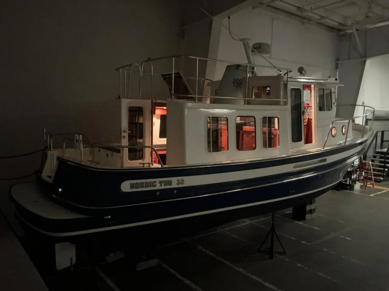 Slide: The Image of 2010 Nordic Tug 32 boat displayed indoors with dim lighting. - 12
