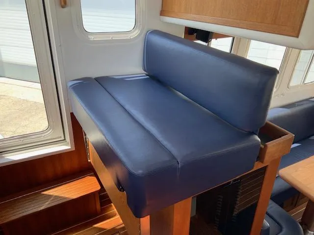 Slide: The Image of Interior of 2010 Nordic Tug 32 with blue cushioned seating and wooden accents. - 17