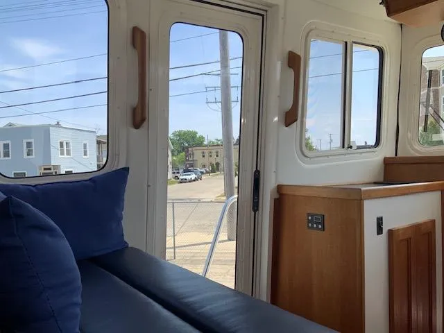 Slide: The Image of Interior view of a 2010 Nordic Tug 32, featuring a cozy seating area. - 18
