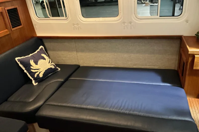 Slide: The Image of Cozy interior of 2010 Nordic Tug 32 with blue seating and crab-themed pillow. - 23