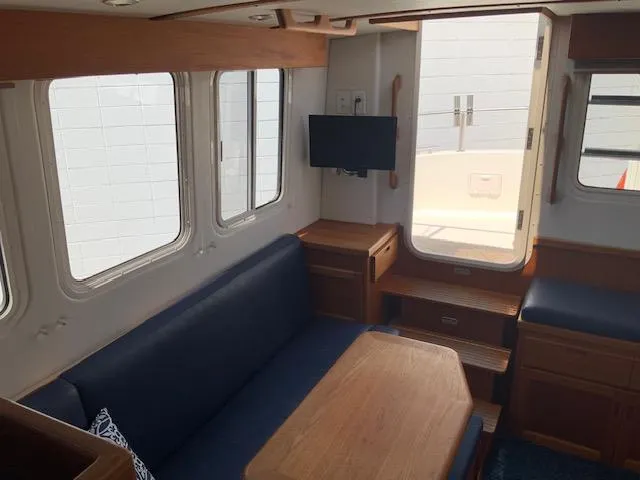 Slide: The Image of Interior of 2010 Nordic Tug 32 with seating, table, and mounted TV. - 25