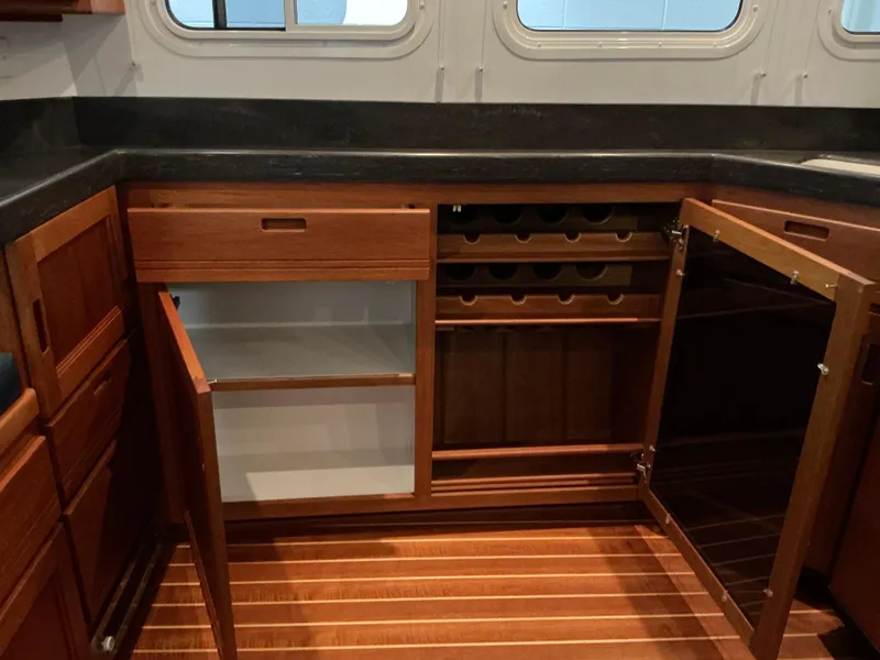 Slide: The Image of Interior of 2010 Nordic Tug 32 with open wooden cabinets and wine rack. - 27