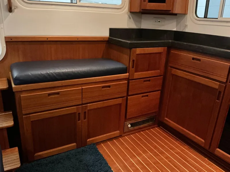 Slide: The Image of Interior of 2010 Nordic Tug 32 with wooden cabinetry and cushioned seating. - 29
