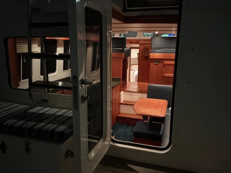 Slide: The Image of Interior view of a 2010 Nordic Tug 32, featuring cozy seating and wooden finishes. - 32