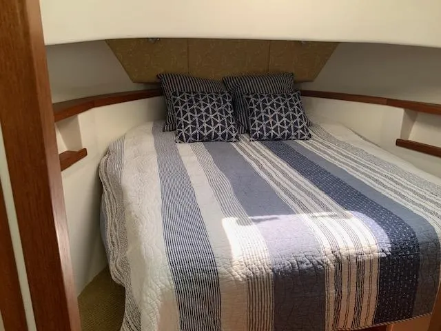 Slide: The Image of Cozy cabin interior of 2010 Nordic Tug 32 with striped bedding and decorative pillows. - 36