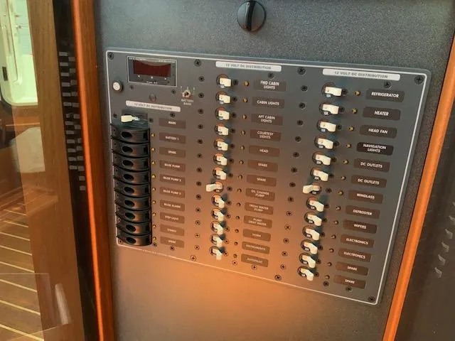 Slide: The Image of Electrical panel of a 2010 Nordic Tug 32 boat, featuring labeled switches and controls. - 38