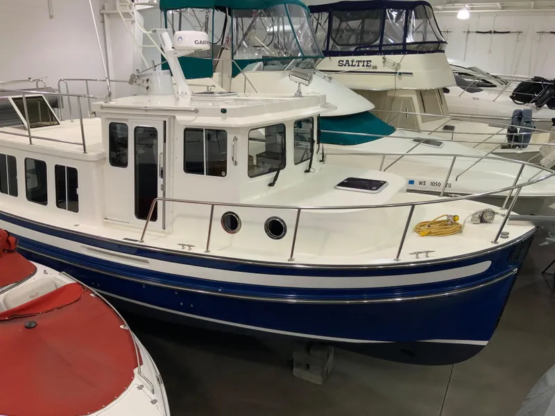 Slide: The Image of 2010 Nordic Tug 32 boat in indoor storage, surrounded by other vessels. - 4