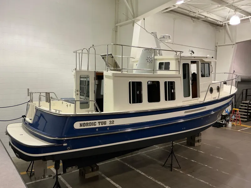 Slide: The Image of 2010 Nordic Tug 32 boat in indoor storage, blue and white exterior. - 6