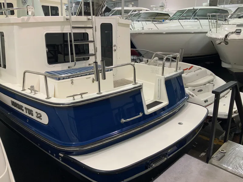 Slide: The Image of 2010 Nordic Tug 32 boat with blue and white exterior in a showroom. - 7