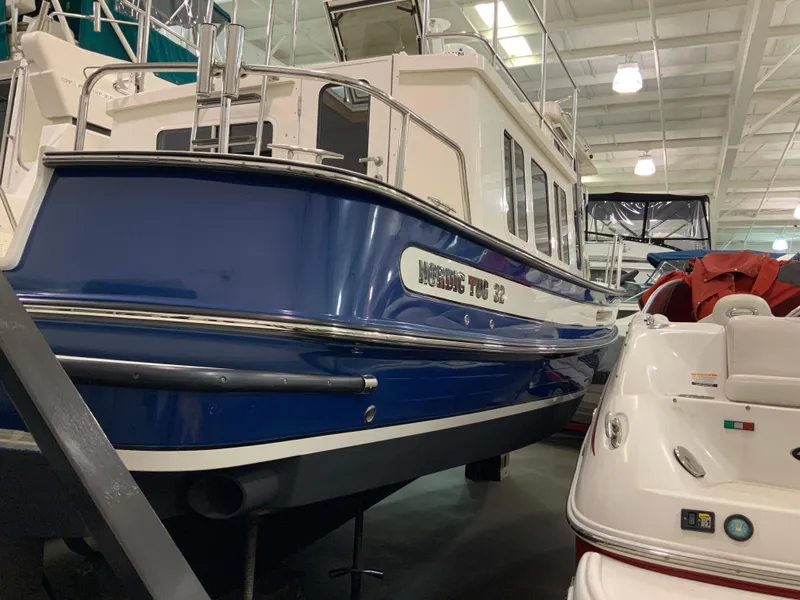 Slide: The Image of 2010 Nordic Tug 32 boat in showroom, blue hull, white cabin, indoor display. - 8