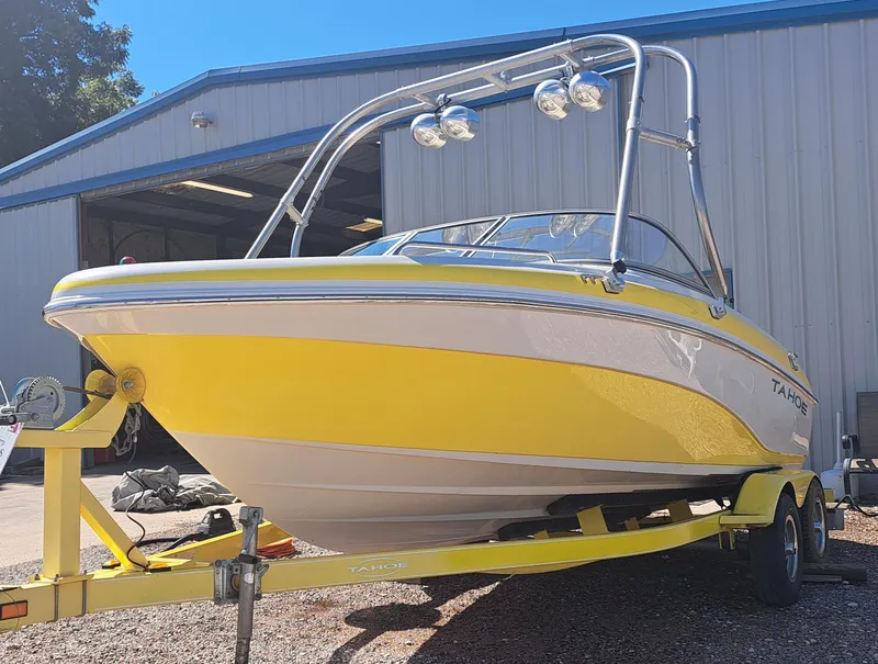 The Image of Yellow 2006 Tahoe Q-6 boat on trailer outside a warehouse. - 0