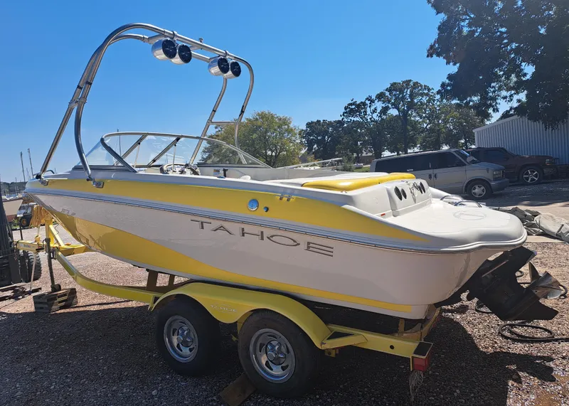 Slide: The Image of Yellow 2006 Tahoe Q-6 boat on trailer, parked outdoors under clear blue sky. - 2