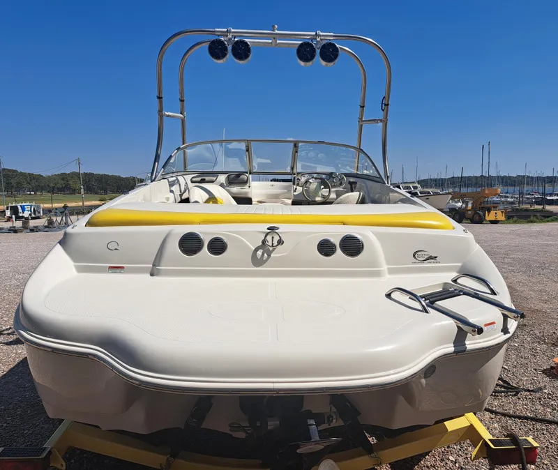 Slide: The Image of 2006 Tahoe Q-6 boat with yellow accents, parked on a trailer at a marina. - 3