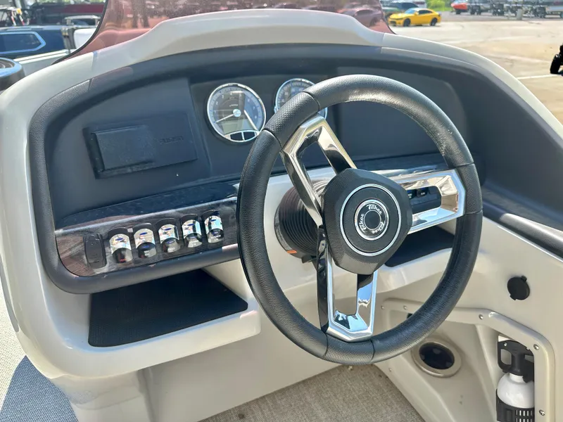 Slide: The Image of 2023 Tahoe Pontoon Cascade Cruise ENT 25 FT Triple 25 WG steering console with controls and gauges. - 9