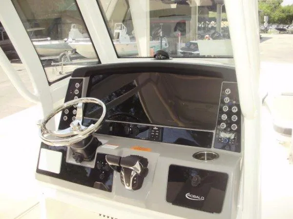 Slide: The Image of 2023 Robalo R250 boat dashboard with steering wheel and control panel. - 11