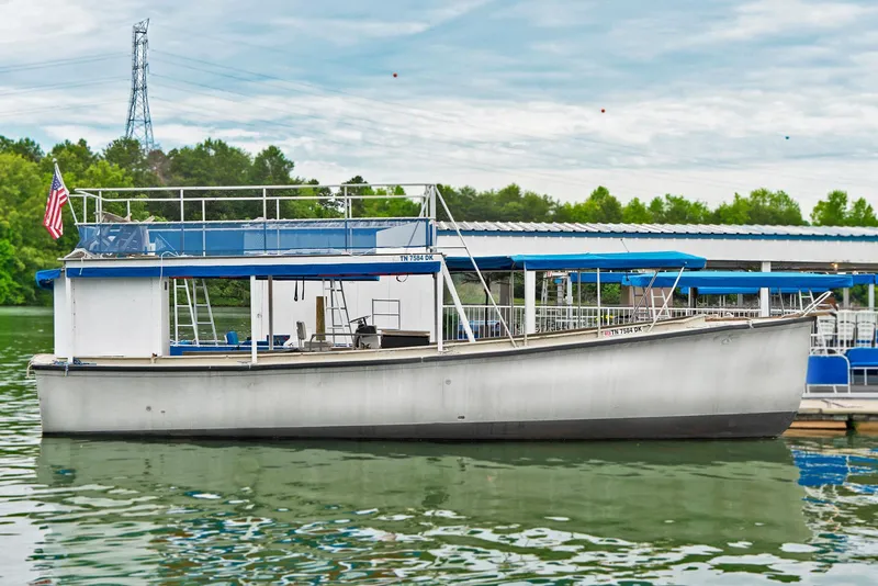 The Image of Custom 40' Navy Boat 2004 docked on calm water with trees and sky in background. - 0