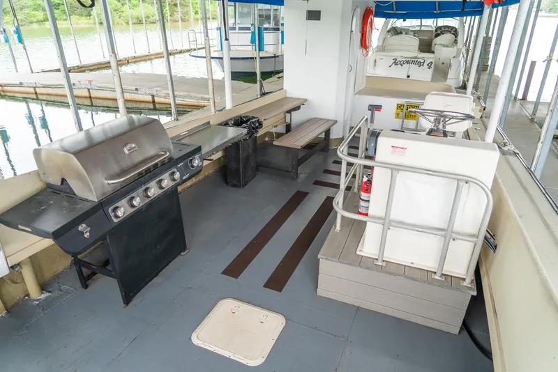 Slide: The Image of Interior of a 2004 Custom 40' Navy Boat with grill and seating area. - 13