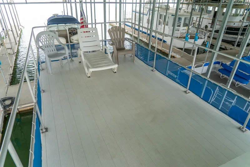 Slide: The Image of Top deck of a 2004 Custom 40' Navy Boat with lounge chairs. - 14