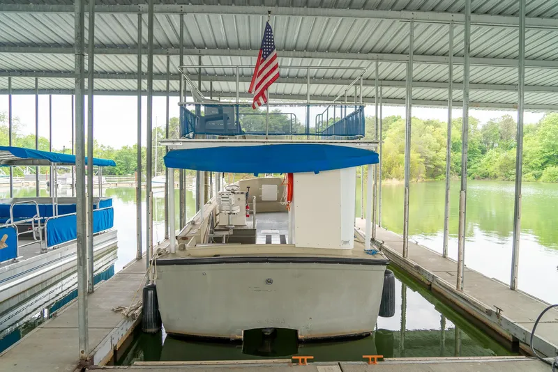Slide: The Image of 2004 Custom 40' Navy Boat docked under a covered marina with an American flag. - 2