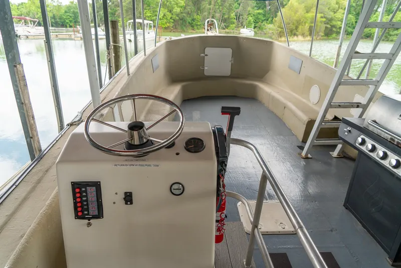 Slide: The Image of Interior of a 2004 Custom 40' Navy Boat with steering wheel and control panel. - 7