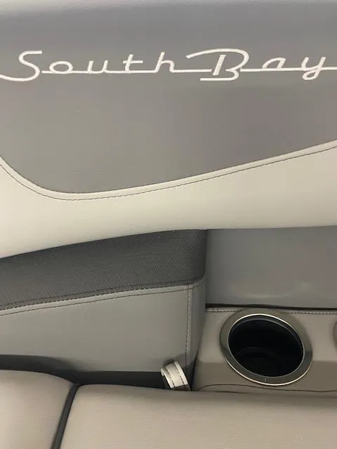 Slide: The Image of 2024 South Bay S222FCR3 boat interior with cup holder and logo. - 7