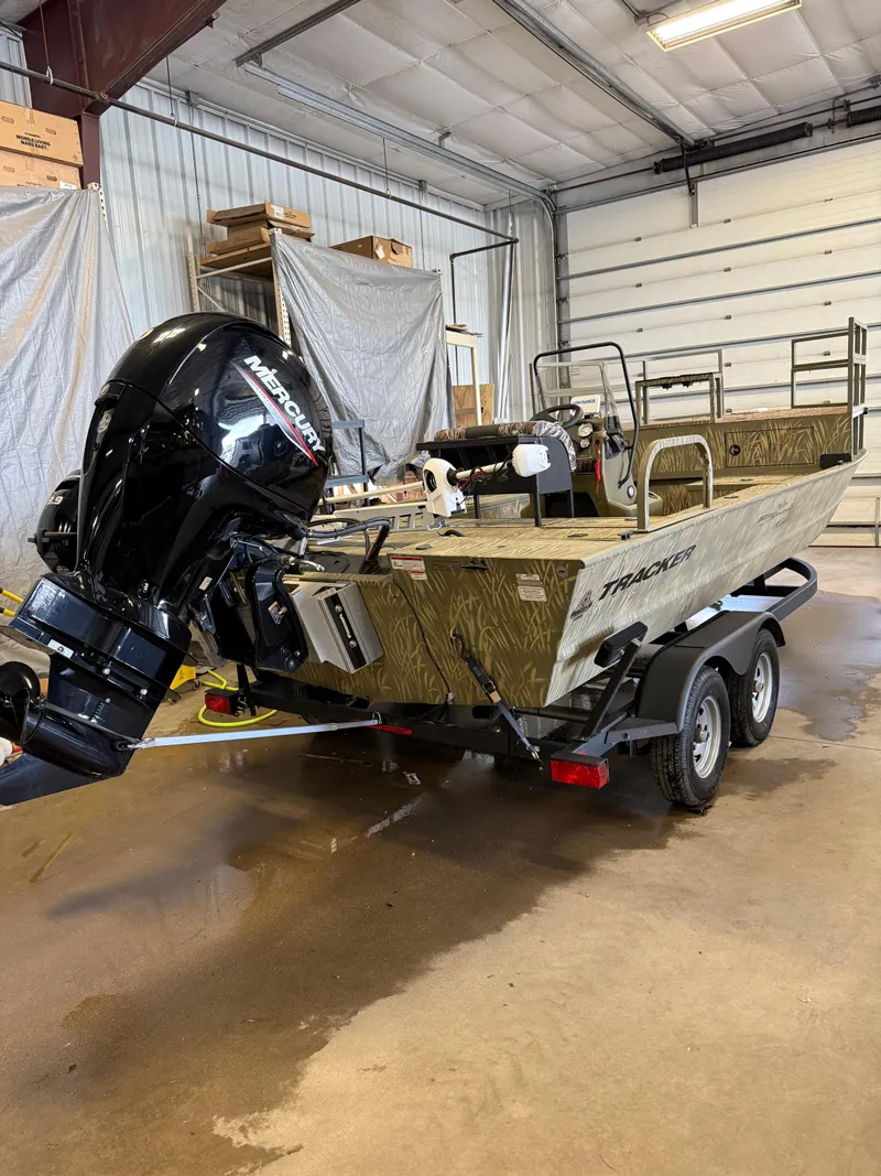 Slide: The Image of 2023 Tracker Grizzly 2072 CC Sportsman boat with Mercury outboard motor in a garage. - 3